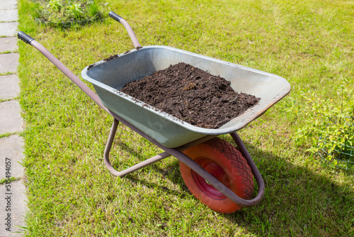 Garden cart with peat on the lawn