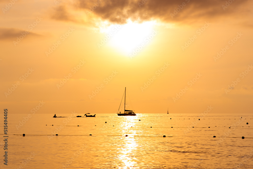 Sunset on the seashore. The silhouette of the yacht against the backdrop of a beautiful sunset. Background. Nature.