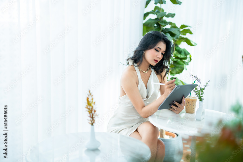 beautiful asian freelance Success people business woman fashion model in summer white sleeveless dress using casual working with tablet for browsing internet, chatting and blogging in coffee shop. beautiful asian freelance Success people business woman fashion model in summer white sleeveless dress using casual working with tablet for browsing internet, chatting and blogging in coffee shop.