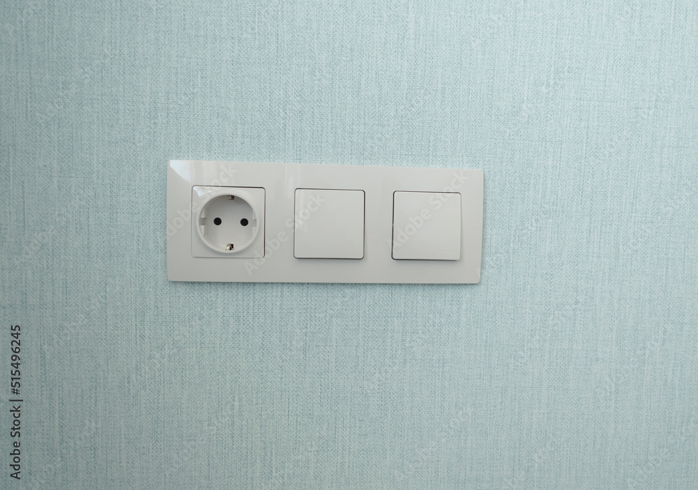 isolated white beige switch and socket on a light wall. aesthetics of electrics, repair, security, interior, design. place for text isolated white beige switch and socket on a light wall. aesthetics of electrics, repair, security, interior, design. place for text