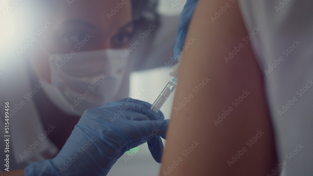 Face woman doctor making vaccine injection to patient visiting hospital close up Face woman doctor making vaccine injection to patient visiting hospital close up