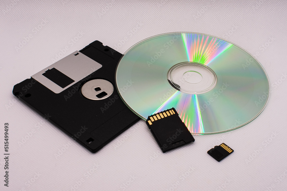 The evolution of memory storage. Floppy disk, CD, and memory cards on a white background close-up. The evolution of memory storage. Floppy disk, CD, and memory cards on a white background close-up.
