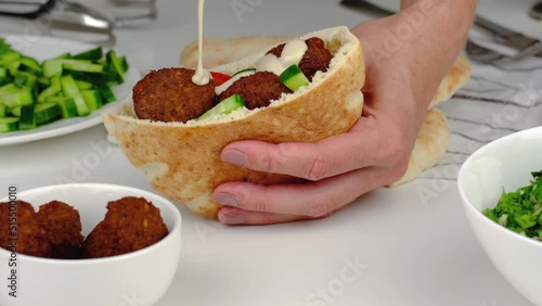 Falafel with vegetables in pita and tahini sauce.