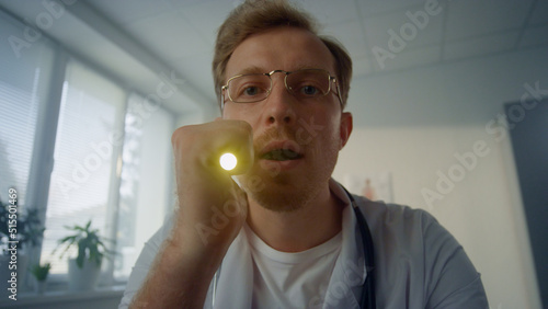 Foto Portrait doctor checking throat using depressor pov video