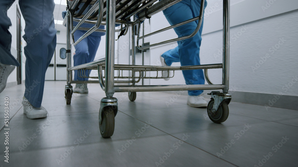 Medics legs running down hospital corridor rolling gurney to emergency room. - obrazy, fototapety, plakaty 