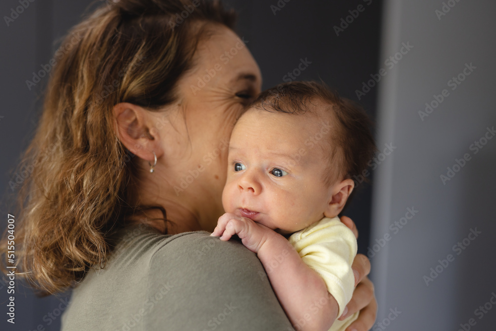 Happy loving mid adult caucasian mother carrying cute newborn baby at home, copy space Happy loving mid adult caucasian mother carrying cute newborn baby at home, copy space