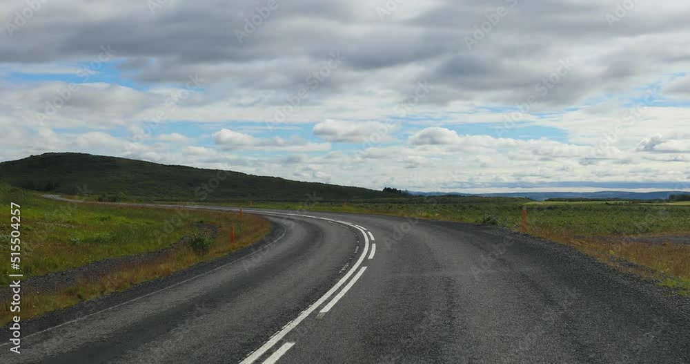 S-curved asphalt road leads to the mountains in volcanic area - İceland S-curved asphalt road leads to the mountains in volcanic area - İceland
