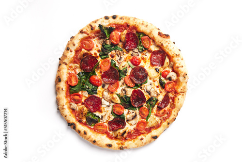 Top view of pizza topped with pepperoni, tomato, roasted garlic, mushroom and spinach on a white background
