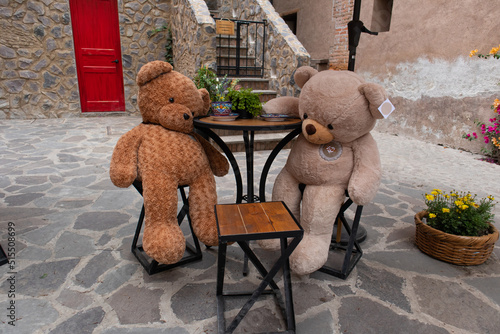 Big Teddy bears at the table in a street restaraurant in a new medieval italian tuscany style town villa in Val'Quirico, Tlaxcala, Puebla, Mexico photo