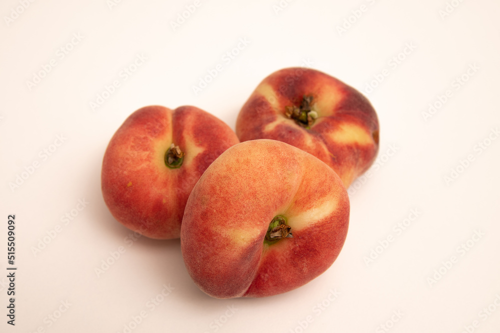 Donut peaches in front of a yellowish white background Donut peaches in front of a yellowish white background