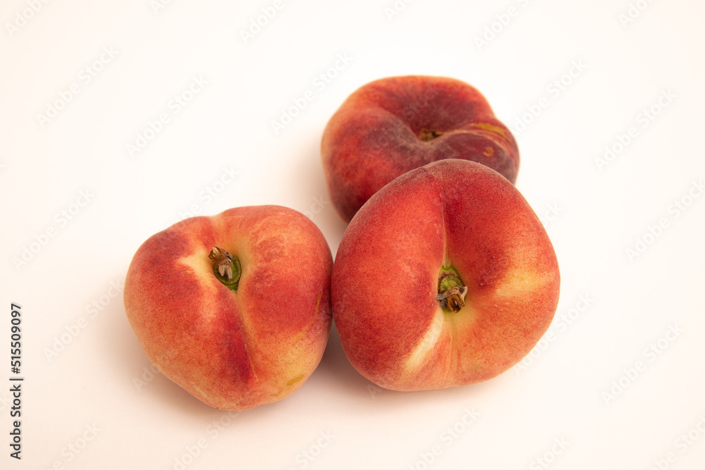 Donut peaches in front of a yellowish white background Donut peaches in front of a yellowish white background