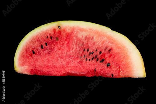 a piece of watermelon lies on a black background