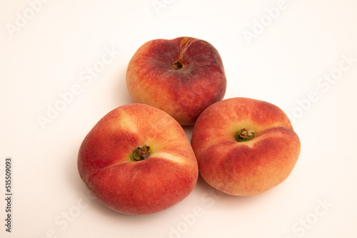 Donut peaches in front of a yellowish white background