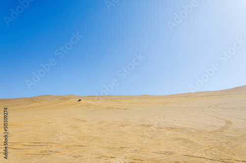 desert with car driving in background - Reserva nacional de Paracas