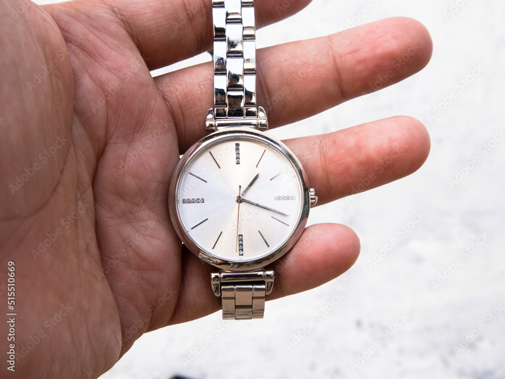 a man holding a gas lighter by stretching the wrist watch strap on a white blurred background a man holding a gas lighter by stretching the wrist watch strap on a white blurred background