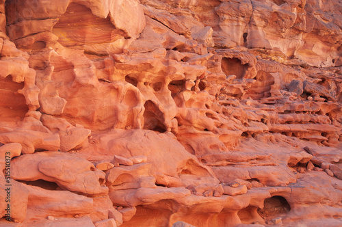 Giant rocky mountains and orange rock formations in desert. Beautiful view of wild nature on sunny summer day.