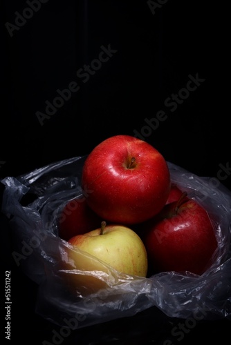 red and green apples in a plastic bag