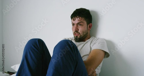 Mentally ill man with a mental disorder in a mental asylum. A drug addict shivering and shaking while sitting in rehab for substance abuse. Recovering addict having withdrawal symptoms in a room photo