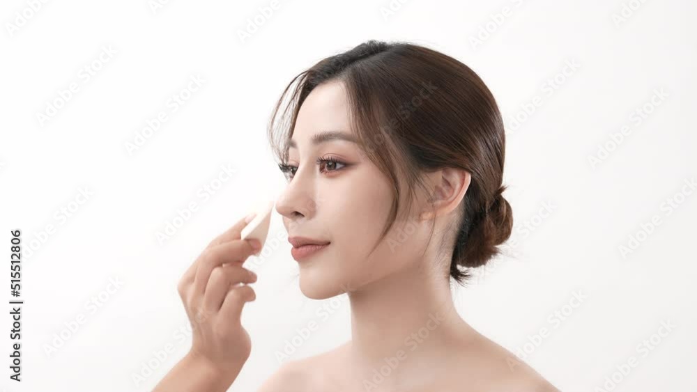 Beauty concept of 4k Resolution. Asian young woman applying face powder foundation on a white background. Beauty concept of 4k Resolution. Asian young woman applying face powder foundation on a white background.