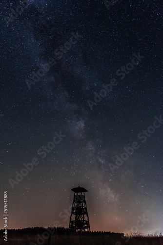 Fototapeta Naklejka Na Ścianę i Meble -  the silhouette of an observation tower at night with a starry sky in the background