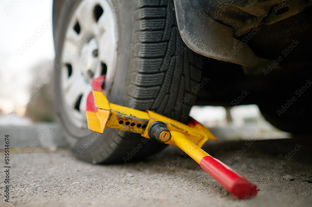 Car wheel blocked by wheel lock. Illegal parking of automobile. Wheel