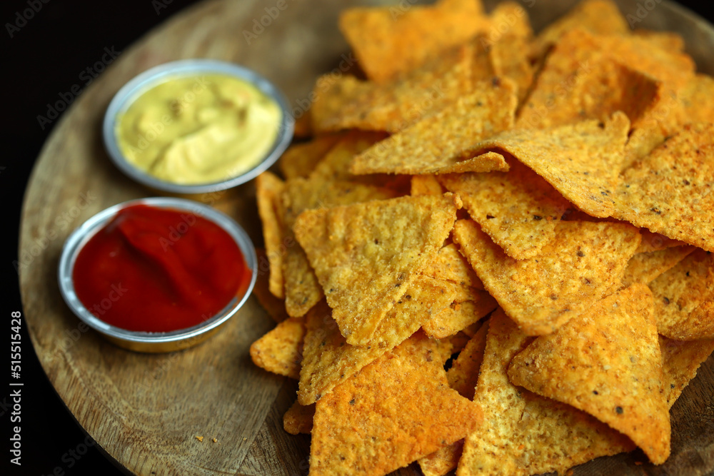 Nachos chips with sauces on a wooden board. Nachos chips with sauces on a wooden board.