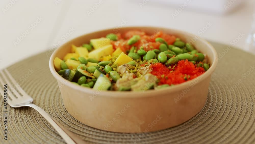 Poke bowl with salmon, rice, avocado, edamame beans, cucumber and radish in gray bowl. Hawaiian ahi poke bowl, gray background. Poke bowl with salmon, rice, avocado, edamame beans, cucumber and radish in gray bowl. Hawaiian ahi poke bowl, gray background.