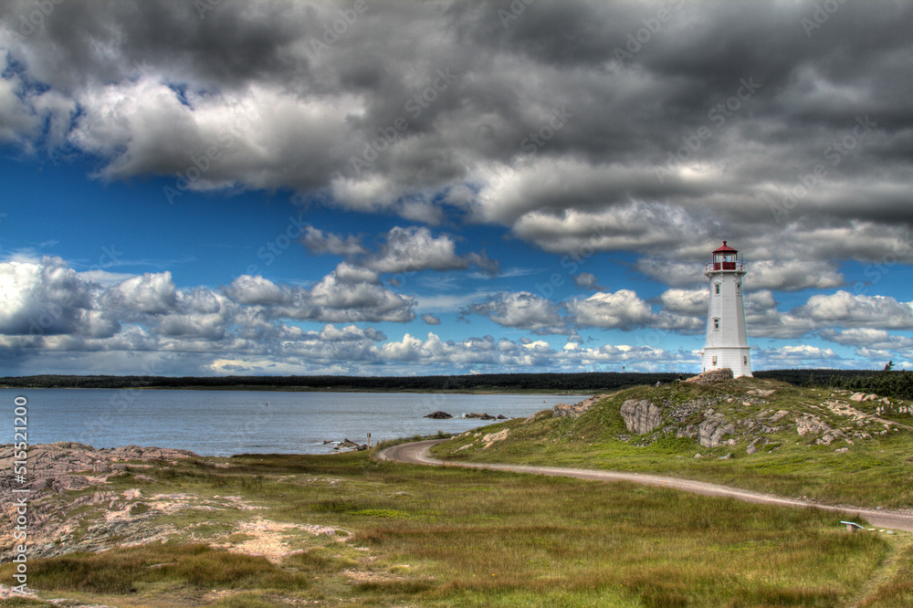 historic lighthouse with dramatic clouds and road