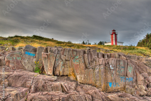 lighthouse with graffiti on rocks