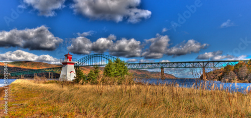 lighthouse with clouds and bridge