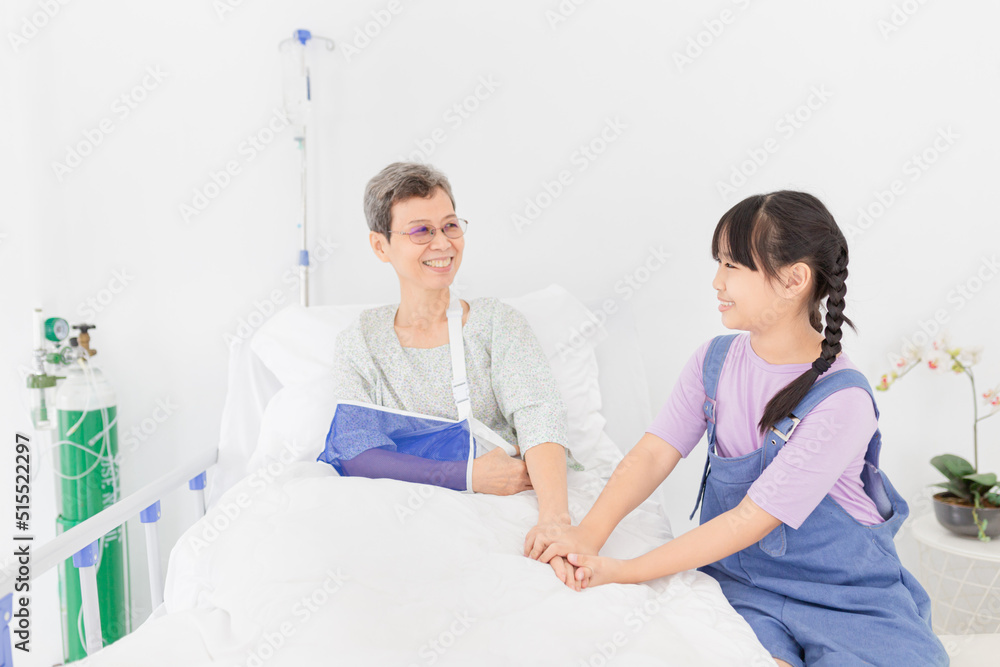 Obraz premium Asian children holding hand of patient in hospital, she visit and care patient, elderly health care, hand in hand