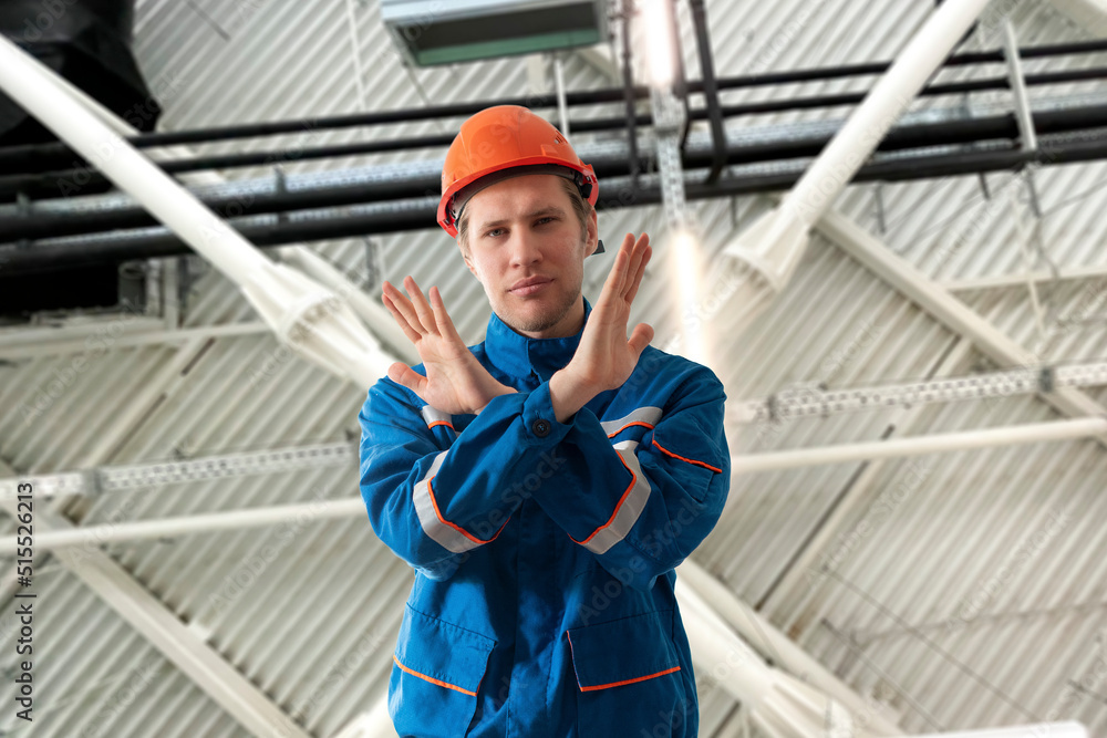 male worker in blue uniform showing the stop gesture male worker in blue uniform showing the stop gesture