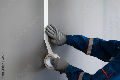 Fotografi paint worker put masking tape on the wall