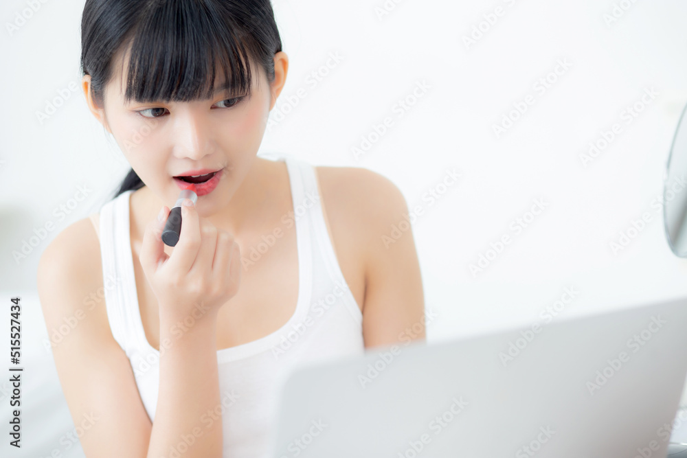Beauty of young asian woman with learning makeup with lipstick on mouth watching laptop computer with tutorial course online, female teaching and explain make up with cosmetic on streaming media. Beauty of young asian woman with learning makeup with lipstick on mouth watching laptop computer with tutorial course online, female teaching and explain make up with cosmetic on streaming media.