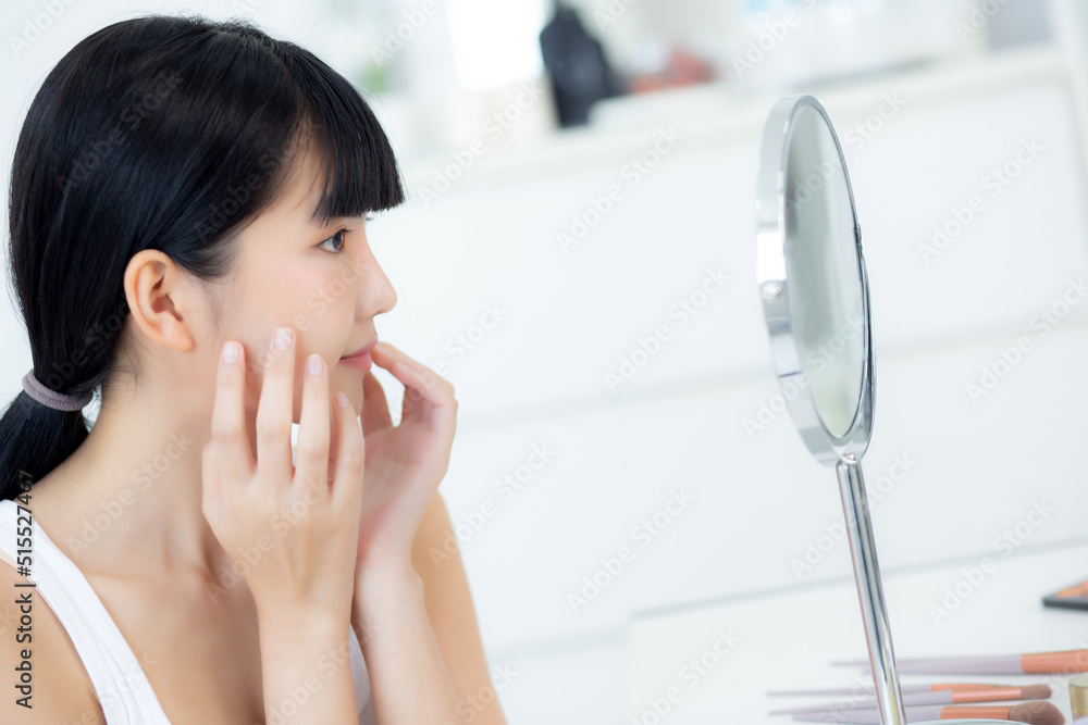 Beautiful face of young asian woman with happy smiling and touch cheek looking mirror with charming, makeup of beauty facial girl with skincare and cosmetic treatment, skin care and healthy concept. Beautiful face of young asian woman with happy smiling and touch cheek looking mirror with charming, makeup of beauty facial girl with skincare and cosmetic treatment, skin care and healthy concept.