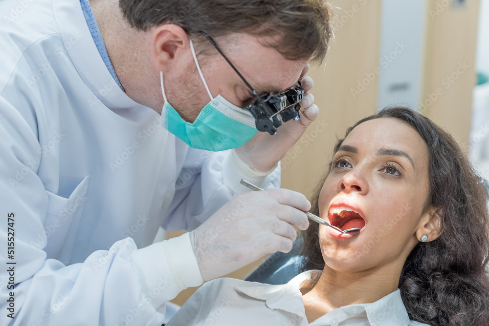 Caucasian male dentist examining young girl patient teeth at dental clinic. Caucasian male dentist examining young girl patient teeth at dental clinic.