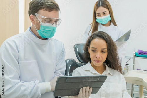 Caucasian male dentist examining young girl patient teeth at dental clinic. 