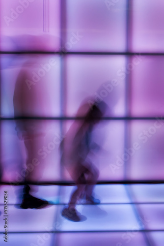 Children dance at the disco on glowing panels, blurry background. Blurry movement of people dancing