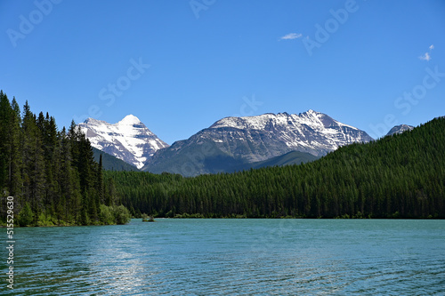 Snow-capped mountains behind Stantion Lake in Great Bear Wilderness, Montana on sunny summer day.