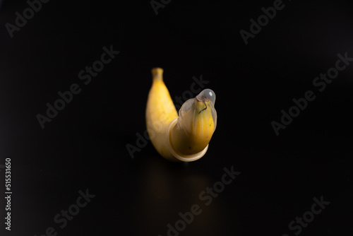 condom and banana on the black color, sex education concept photo