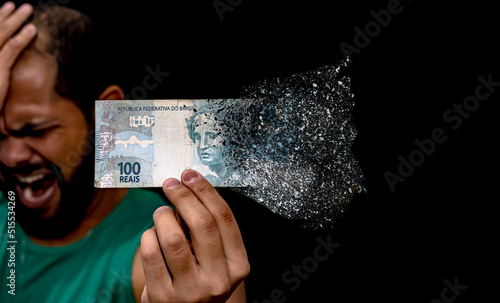 Inflation eating away at money. 100 reais note in Portuguese, in Brazilian currency.