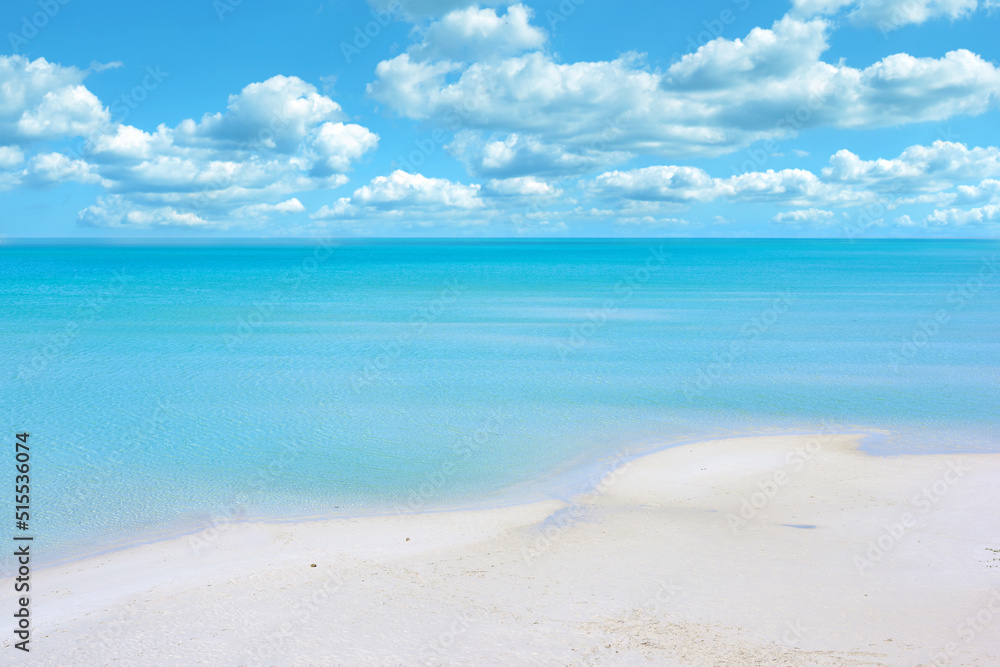 Copy space at the beach with a cloudy blue sky background above the horizon. Calm ocean water across the sea along the shore. Peaceful and tranquil landscape for a relaxing and zen summer getaway