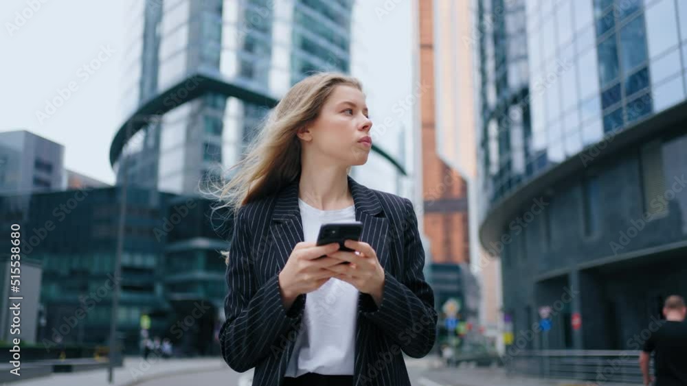 Beautiful Young Woman Using Smartphone Walking Through City Street Day Light. Portrait of Smiling Female Using Mobile Phone, Posting Social Media, Online Shopping, Texting