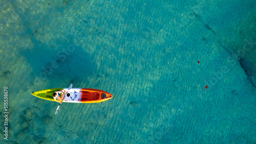 Aerial view of a kayak in the blue sea .Woman kayaking She does water sports activities. © Photo Sesaon