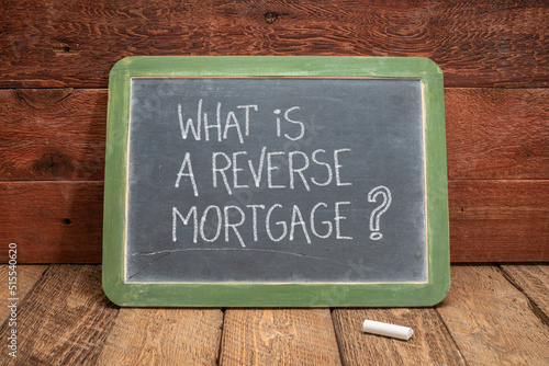 What is a reverse mortgage? A question written in white chalk on a slate blackboard, finance and retirement concept photo