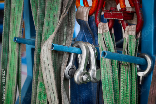 Rigging equipment with strops hangs on rack in warehouse