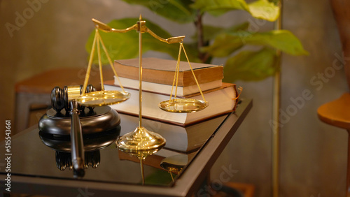 Lawyer or judge's hammer in the court. Auction's hammer is on woo table. Law subject or auction firm with book and golden judge's scale as symbol.