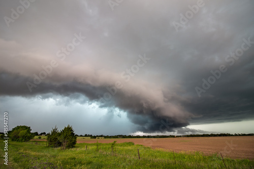 A shelf cloud and severe storm filled with rain and hail over a farm field in Kansas.
