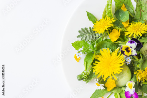 Fresh dandelion salad with onion, cucumber and olive oil on a plate. Isolated on the white background.