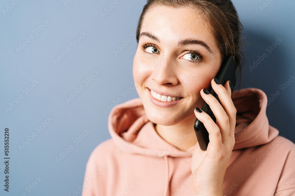 Young woman talking on her cell phone and look to the side Young woman talking on her cell phone and look to the side